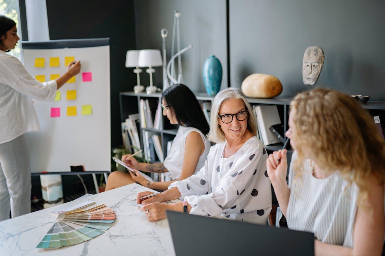 Services Diverse women collaborating in a stylish office during a creative brainstorming session with post-it notes.